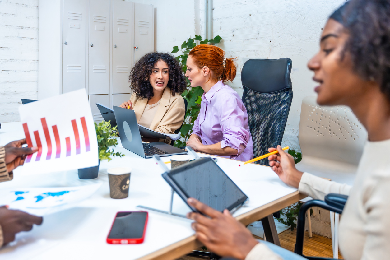 A nonprofit program manager collaborates with a colleague in an office. 