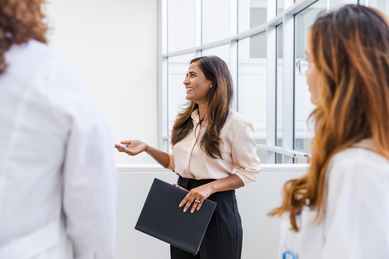 Health administrator talking to doctors in a medical facility.