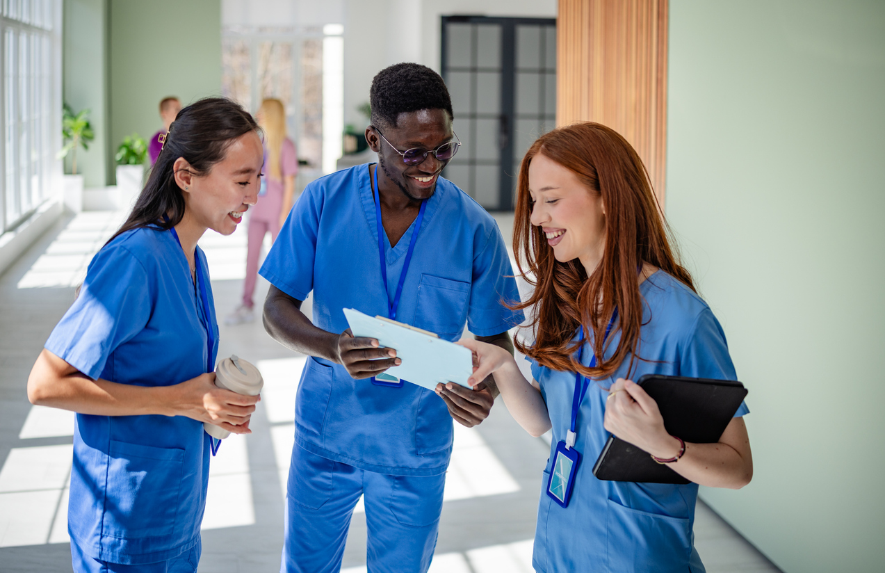 Nurses Standing and Smiling in a Hallway of a Health Care Facility