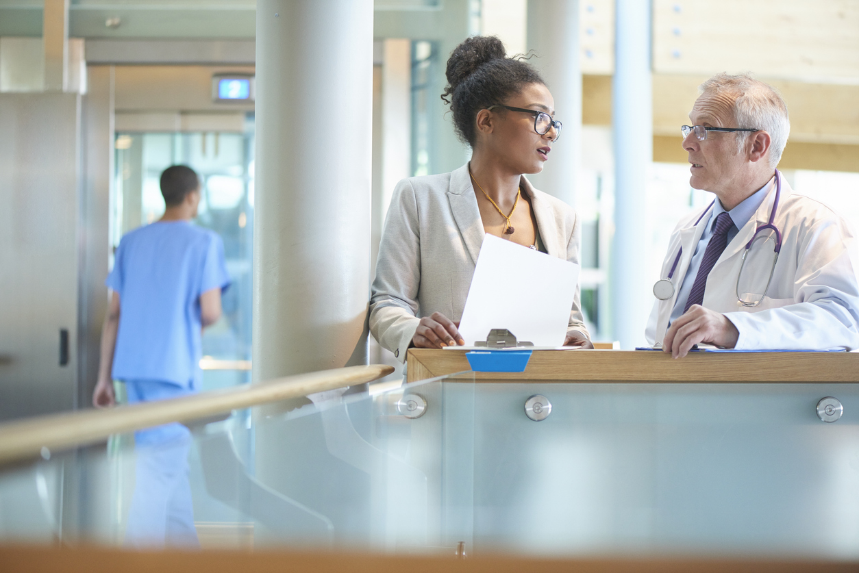 Patient Care Manager Talking to a Doctor in a Medical Facility..jpg