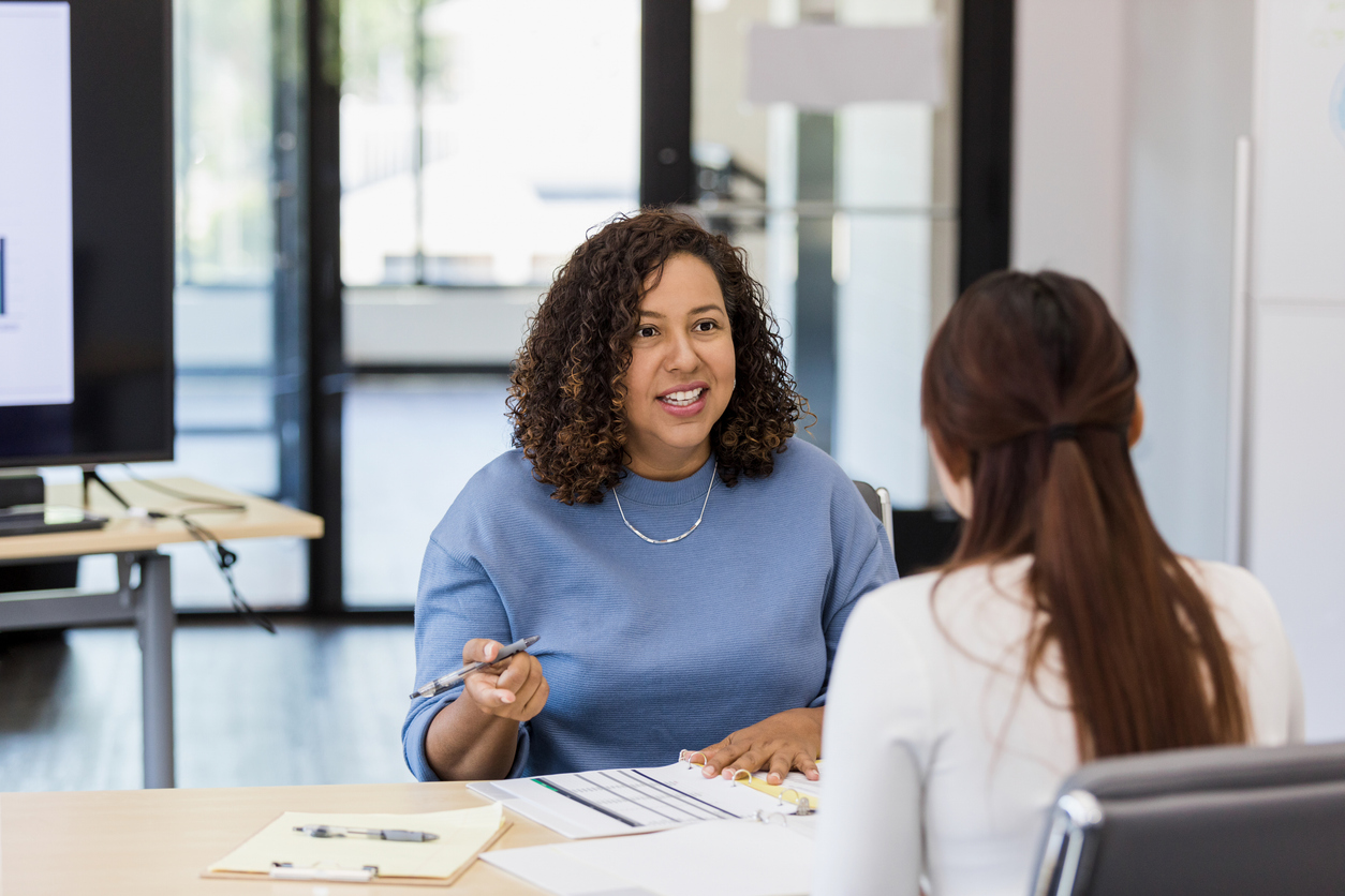 A Mental Health Education Specialist Seated at a Desk Speaks With a Client..jpg
